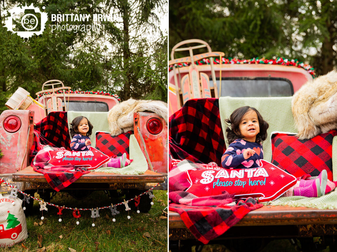 santa-please-stop-here-one-year-old-girl-christmas-portrait-with-pillow-in-classic-truck.jpg