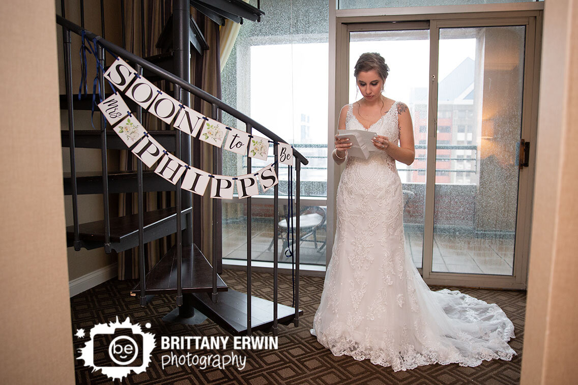 bride-reading-letter-note-from-groom-by-spiral-staircase.jpg