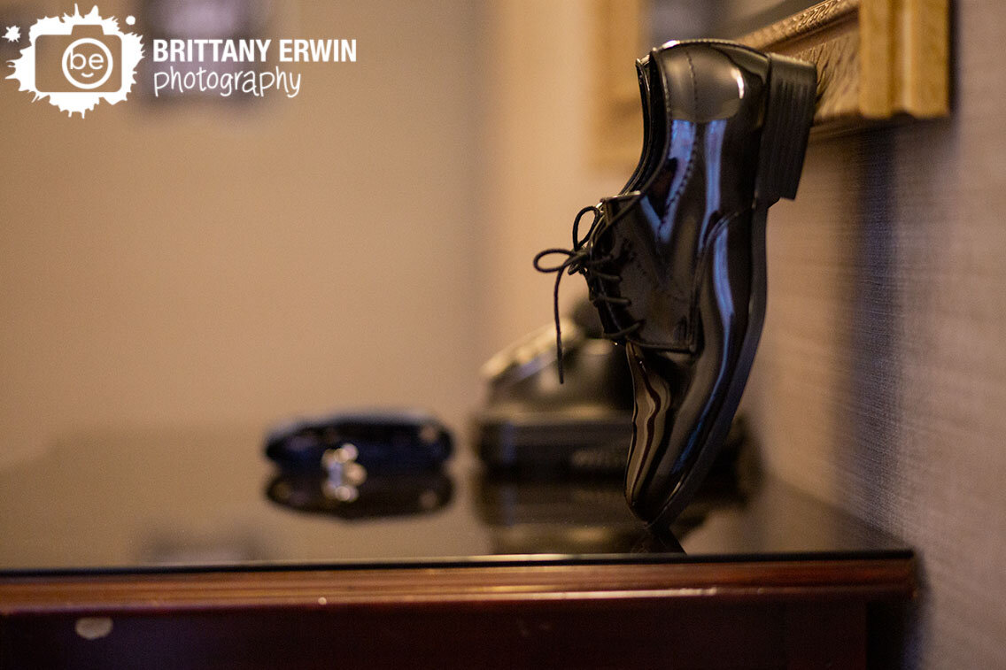 groom-details-on-dresser-shoes-leaning-on-mirror.jpg