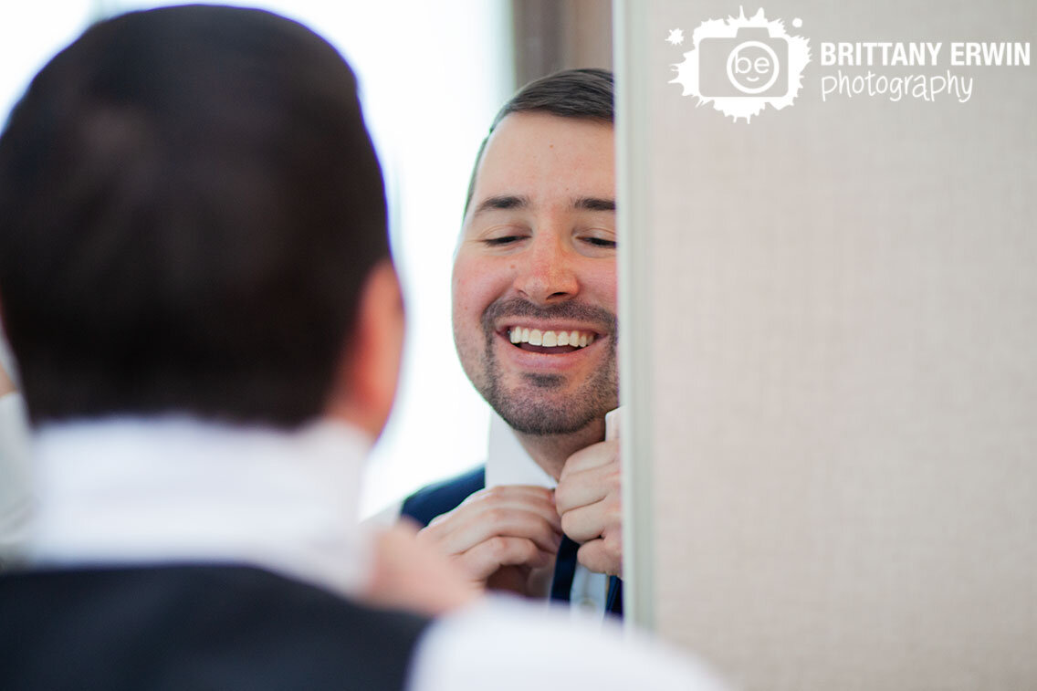 groom-getting-ready-putting-on-tie-in-mirror.jpg