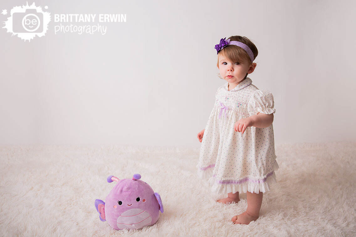 Toddler-baby-girl-on-seamless-backdrop-with-fuzzy-floor-faux-fur-butterfly-lovey.jpg