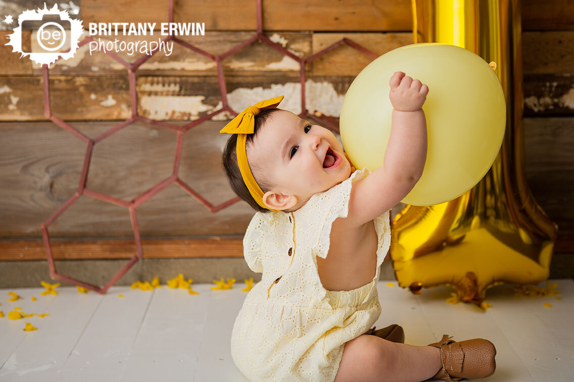 baby-girl-playing-with-yellow-balloon-gold-one.jpg
