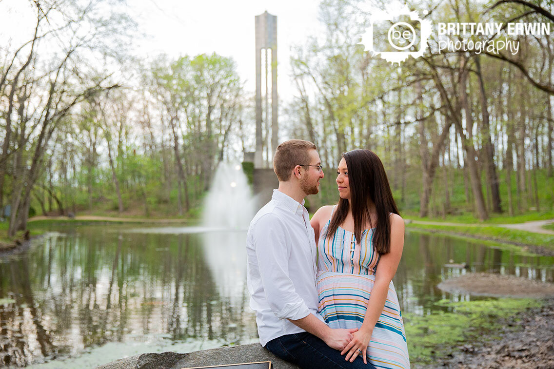 Indianapolis-holcomb-Gardens-couple-by-pond-with-tower-and-water-fountain.jpg