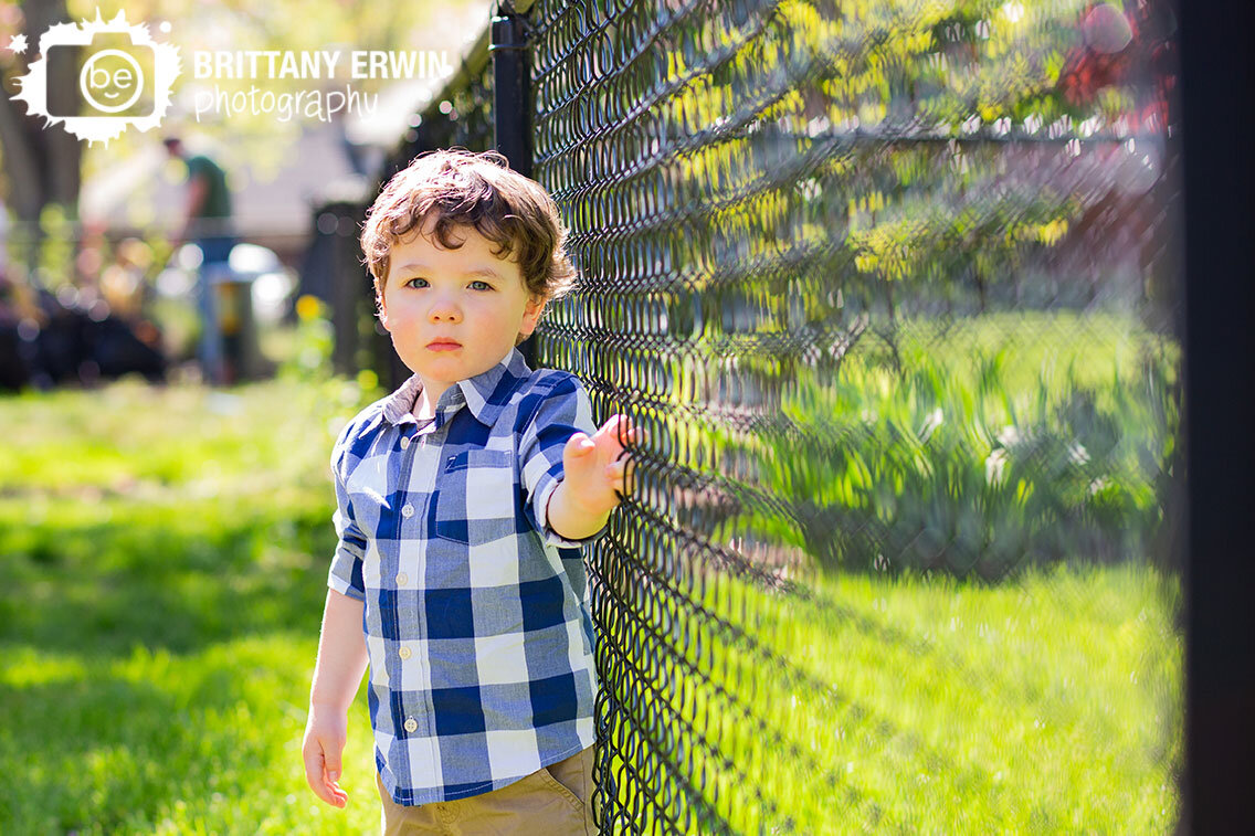 Serious-boy-by-fence-at-home-session-social-distance-portraits.jpg