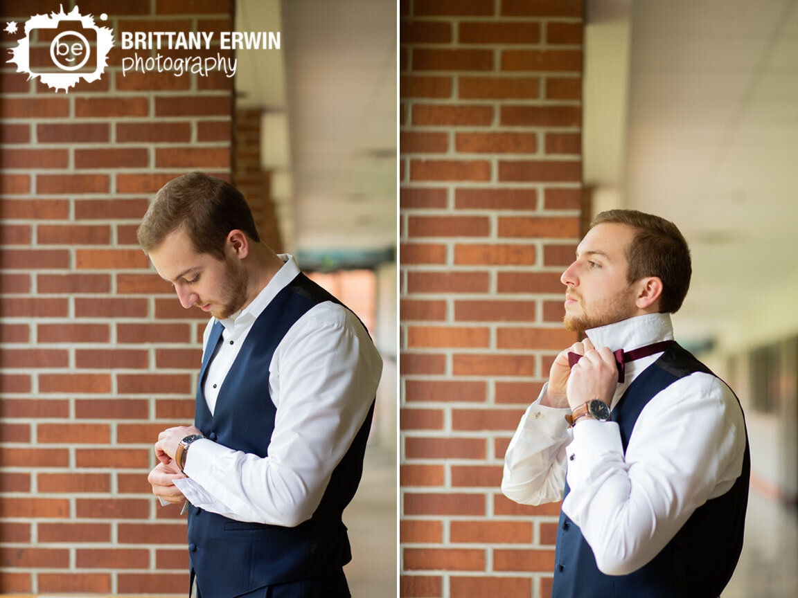 Wedding-photographer-groom-putting-on-bowtie-in-window.jpg