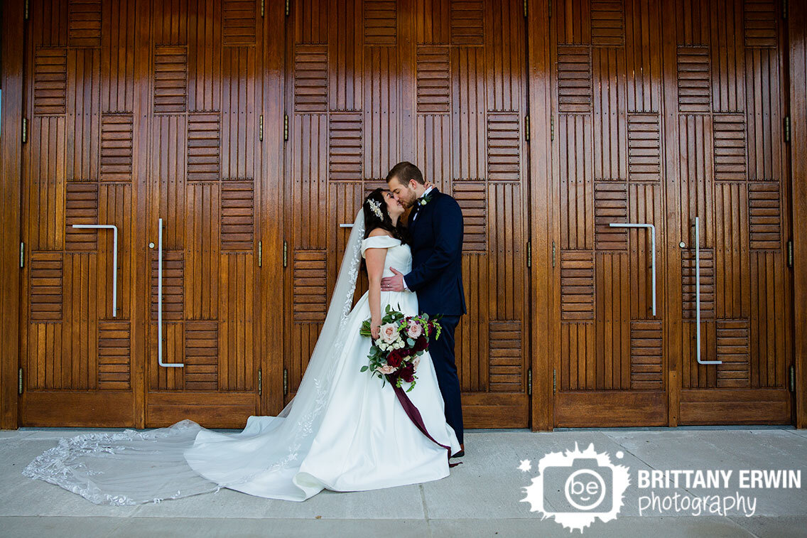 First-Christian-Church-wedding-photographer-couple-with-wood-front-doors-modern-art-deco-style.jpg