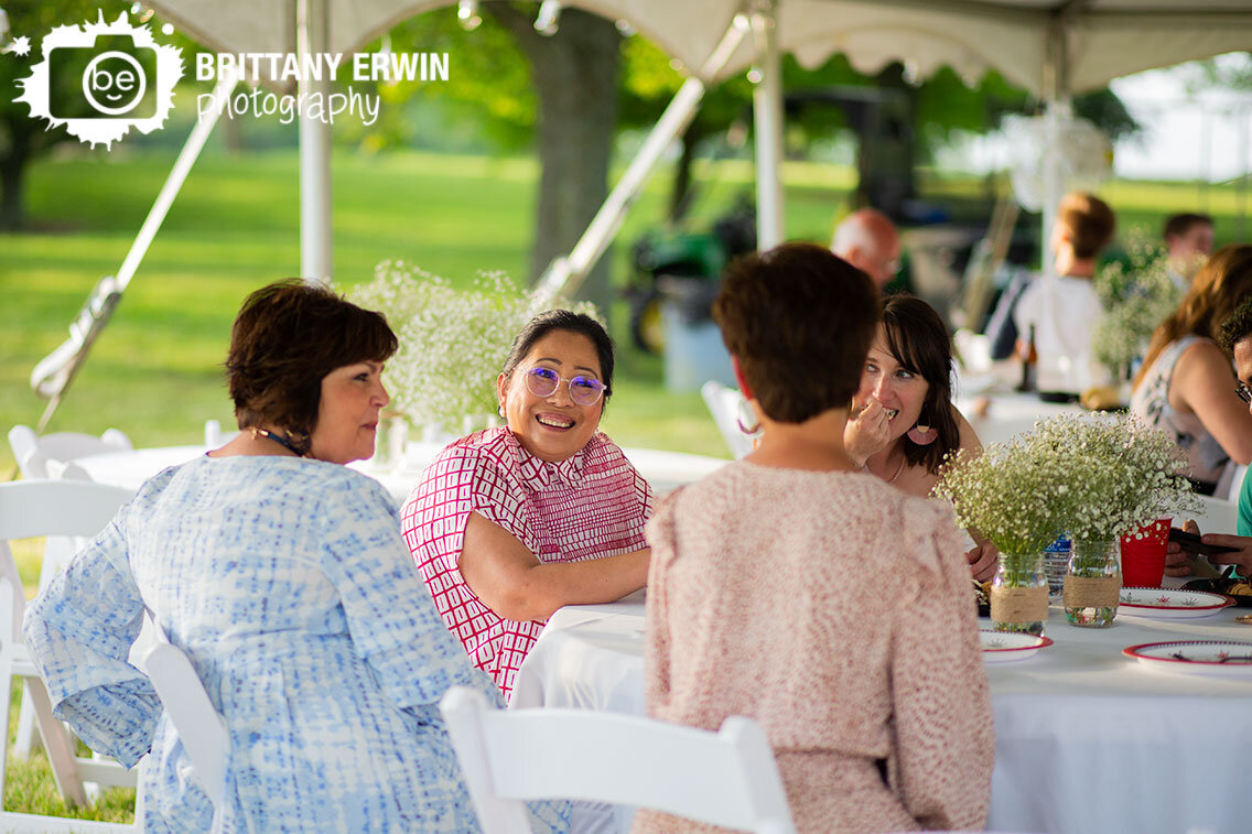 backyard-wedding-photographer-mother-of-bride-talking-with-family-at-reception.jpg