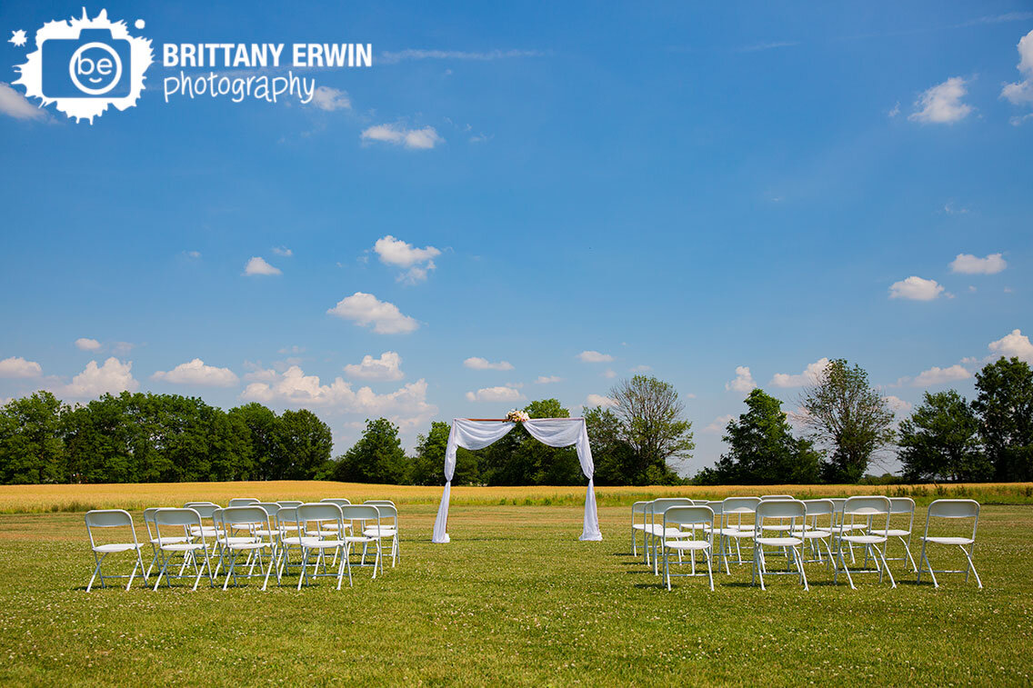 outdoor-backyard-summer-wedding-blue-sky-white-chairs-drapery-copper-arch-with-flowers.jpg