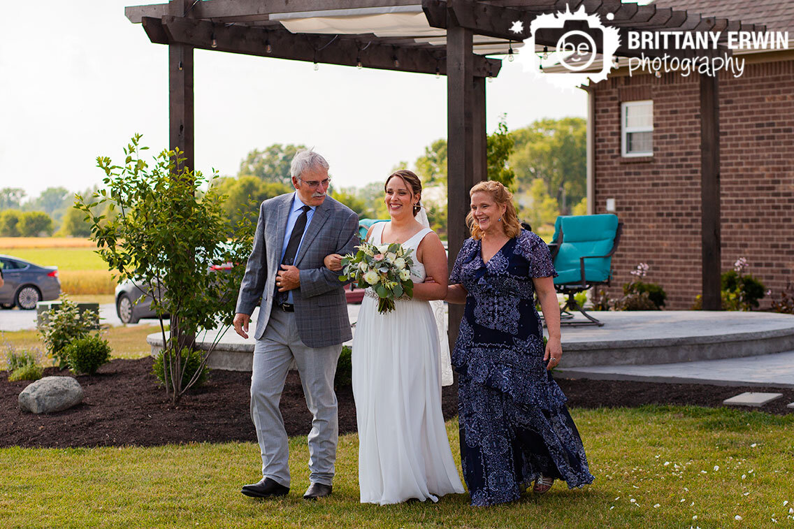 Indianapolis-wedding-photographer-outdoor-backyard-ceremony-bride-walking-down-with-mother-and-father.jpg