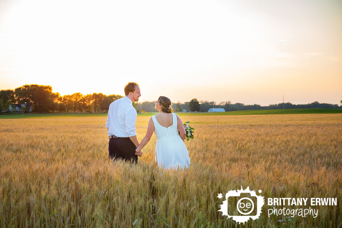 Indianapolis-hay-field-sunset-wedding-portrait-photographer-couple-walking-through-tall-grass.jpg