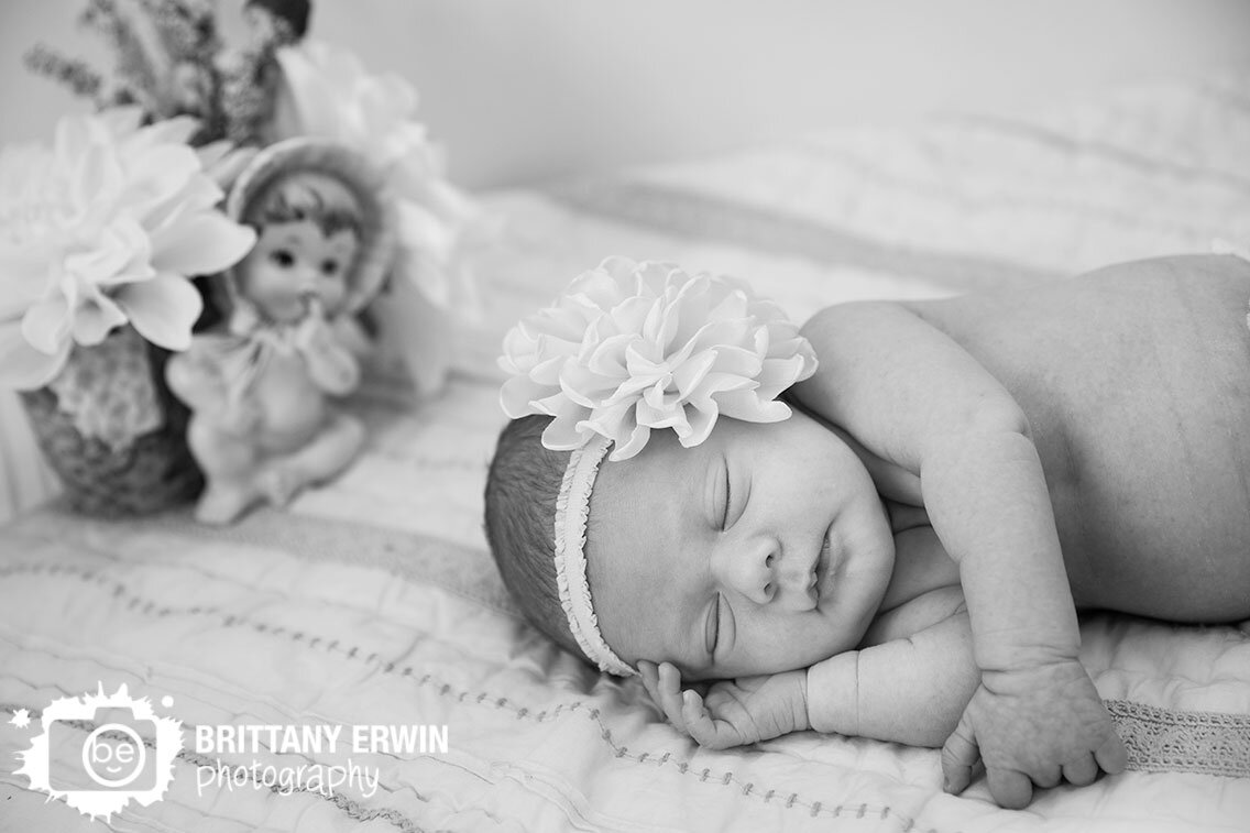 Lifestyle-newborn-portrait-photographer-baby-girl-sleeping-in-crib-with-flower-arrangement.jpg
