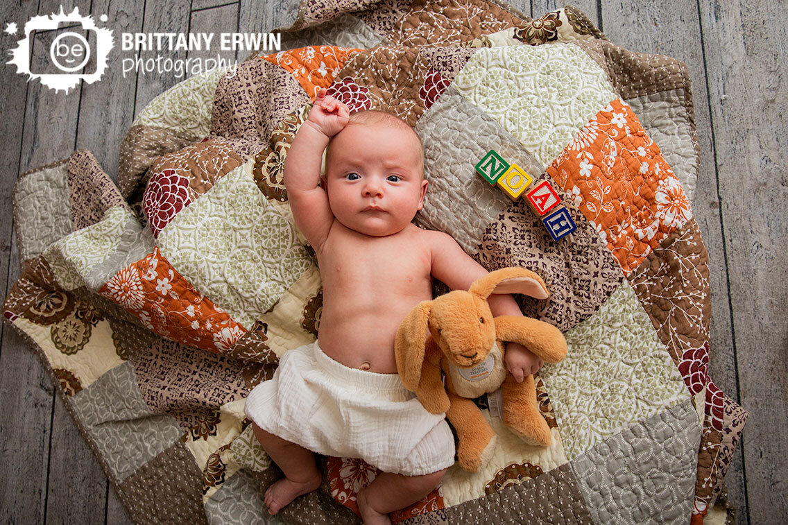 Indianapolis-portrait-studio-photographer-baby-boy-milestone-portrait-silly-with-bunny-on-quilt.jpg