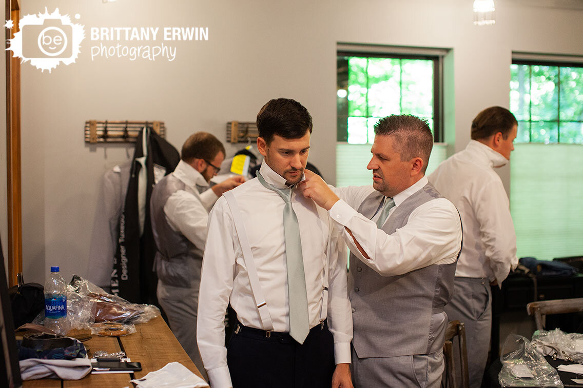 groomsman-helping-groom-with-tie-at-wedding.jpg
