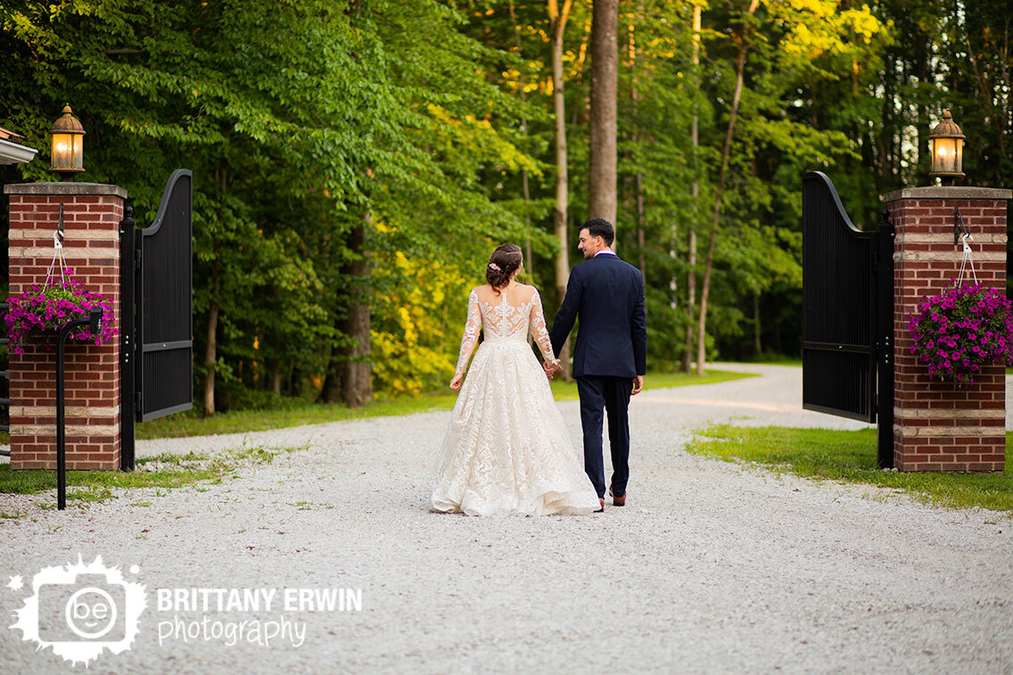 3-fat-labs-wedding-photographer-couple-walking-through-gate-summer-venue-flowers.jpg