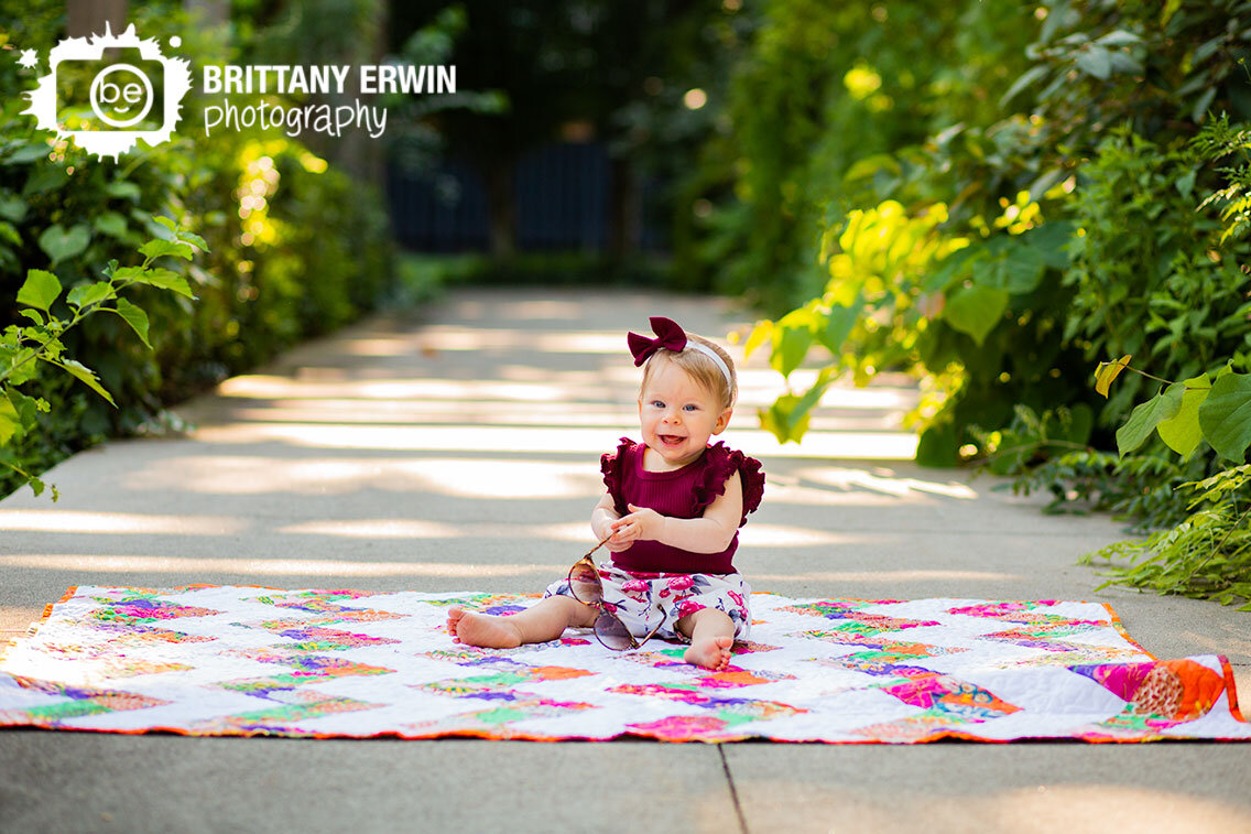 Indianapolis-Art-Center-milestone-portrait-photographer-baby-girl-playing-with-sunglasses-on-quilt.jpg