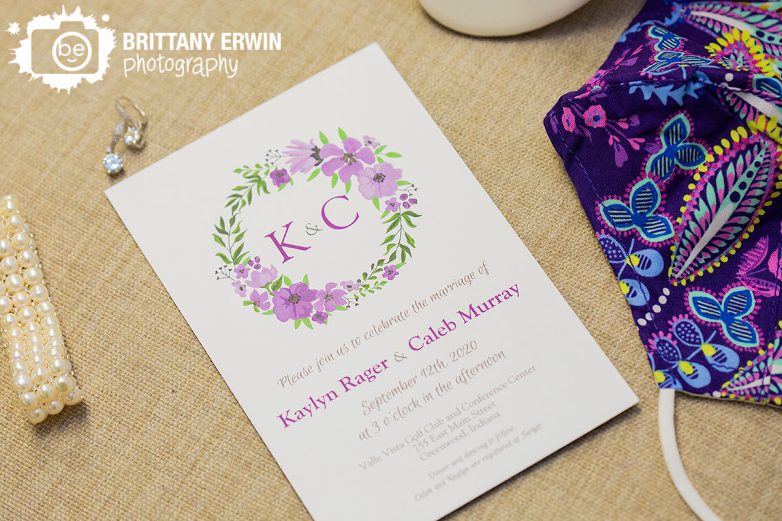 wedding-invitation-detail-with-earrings-mask-and-bracelet-on-chair.jpg