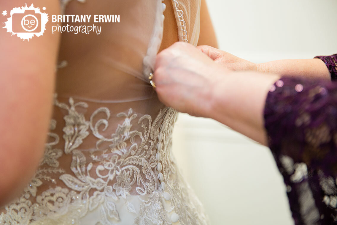 bride-getting-ready-putting-dress-on-with-mother-button-back.jpg