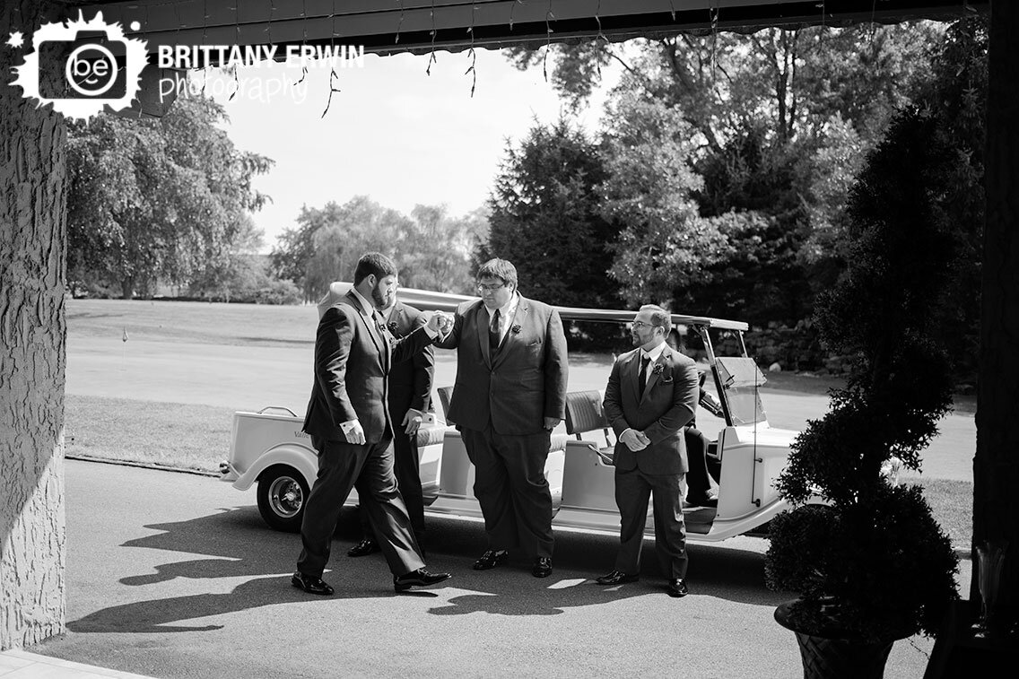Groom-arriving-in-gatsby-golf-cart-at-Valle-Vista-wedding-ceremony-venue-fist-bump-groomsmen.jpg