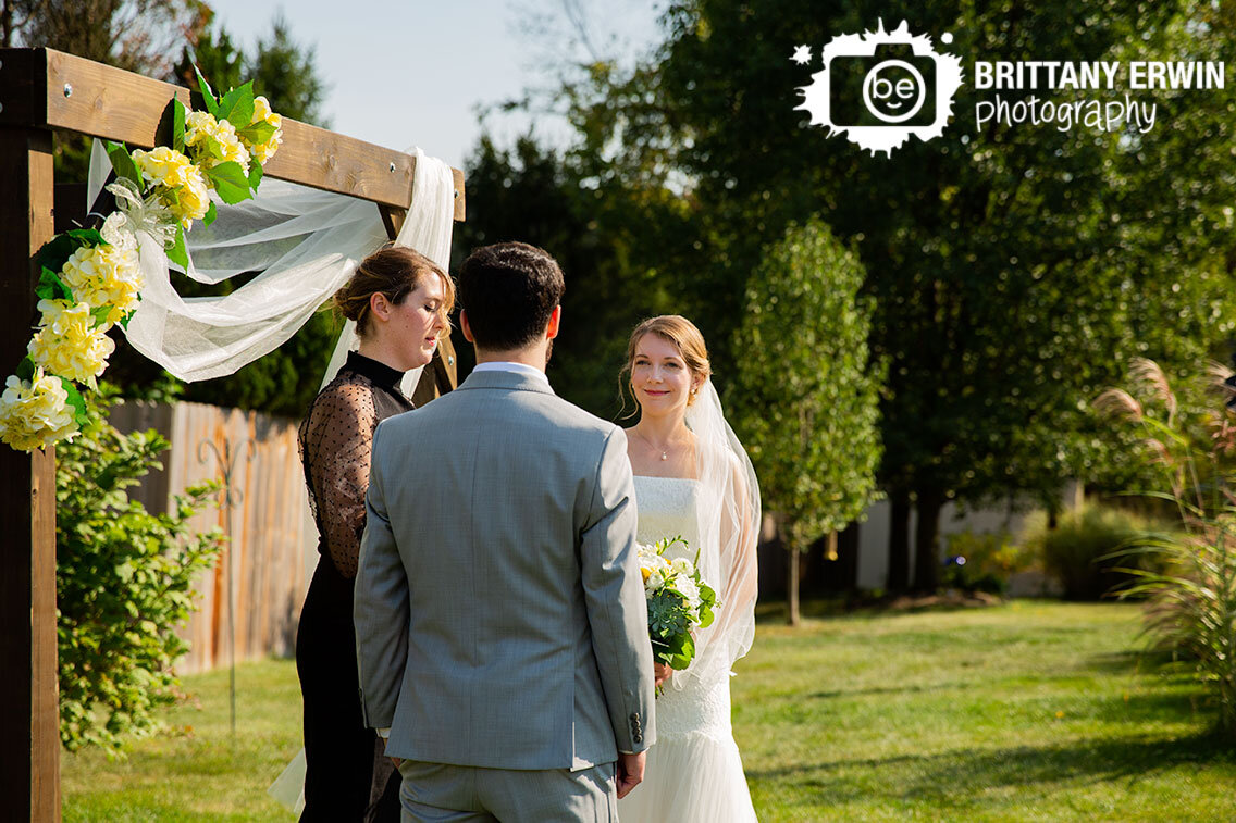 Backyard-wedding-ceremony-couple-at-altar-friend-officiating.jpg