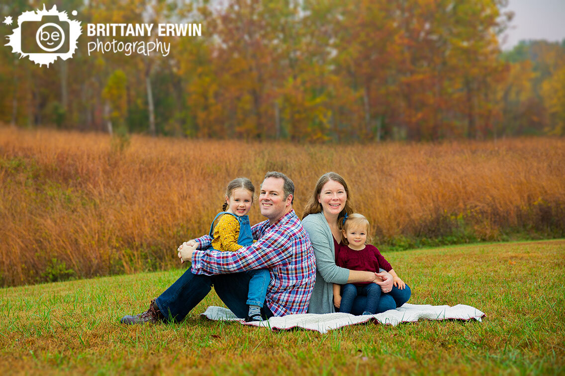 family-fall-portrait-sitting-together-on-blanket-with-tall-grass.jpg