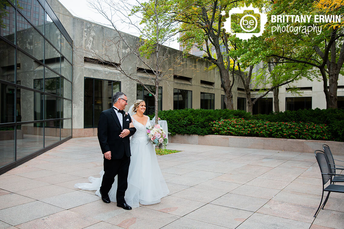bride-walking-down-aisle-at-wedding-ceremony-outdoor-fall-in-courtyard.jpg