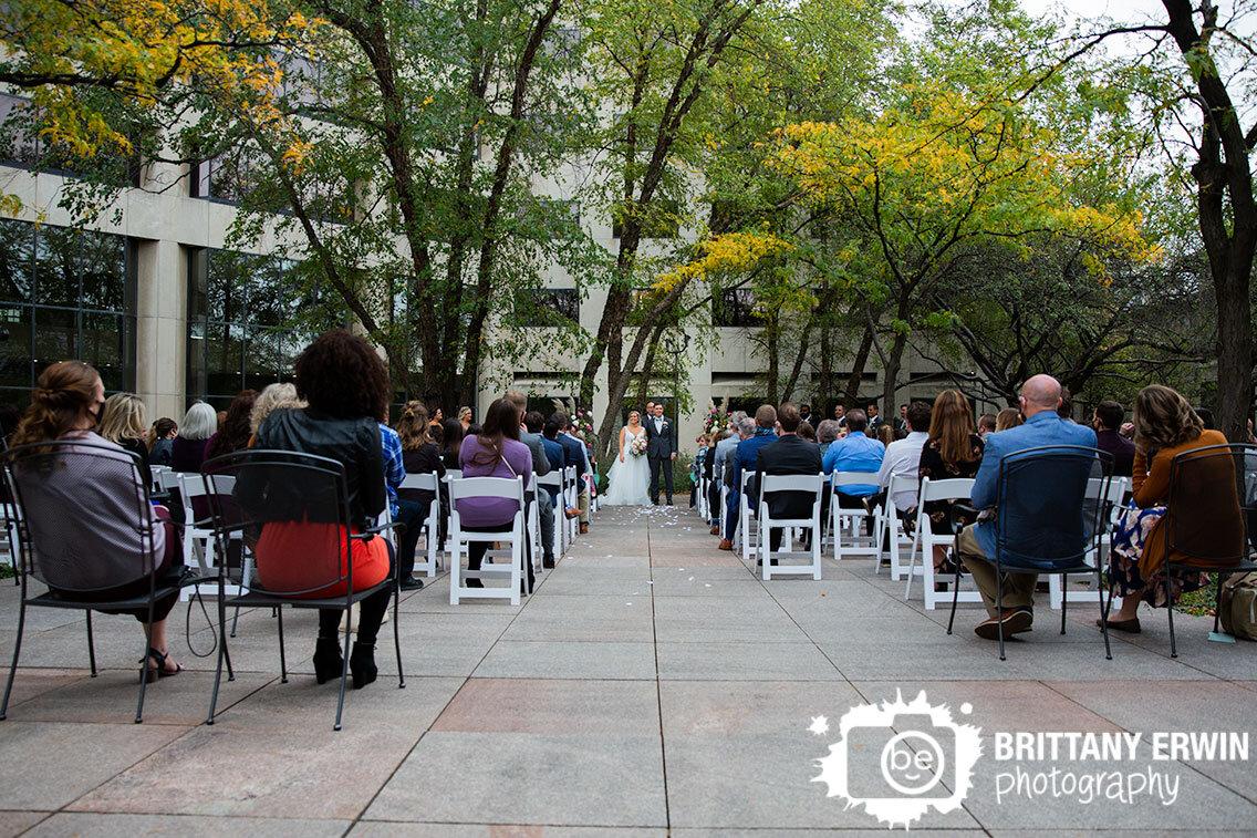 Downtown-Indianapolis-wedding-ceremony-photographer-couple-look-out-at-guests.jpg