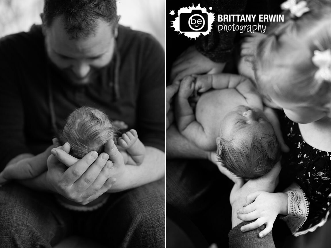 Indianapolis-newborn-portrait-photographer-in-home-session-father-holding-baby-boy-hands-siblings.jpg