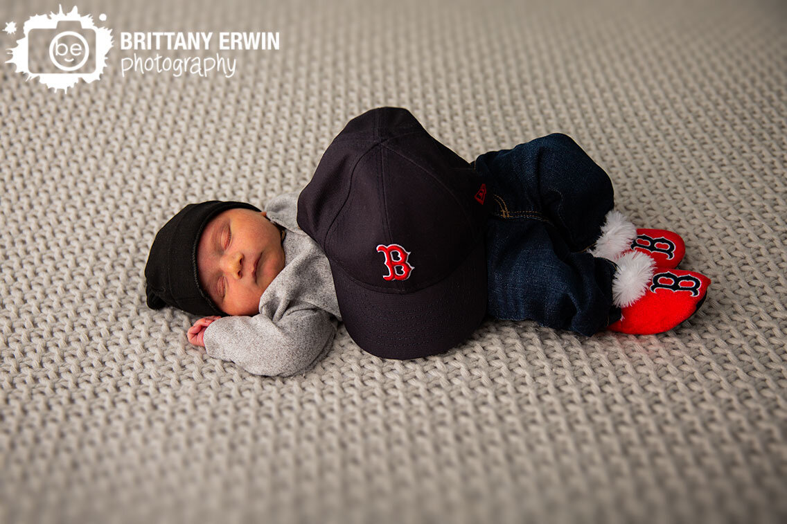 Indianapolis-newborn-baby-boy-sleeping-on-knit-blanket-jeans-booties-boston-redsocks-hat.jpg