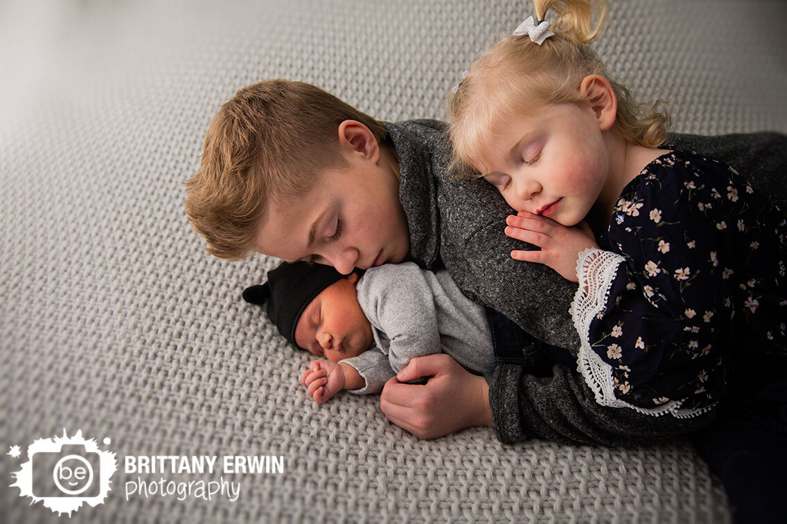 Indianapolis-in-home-portrait-photographer-baby-boy-big-brother-sister-sleeping-snuggled-on-knit-blanket.jpg