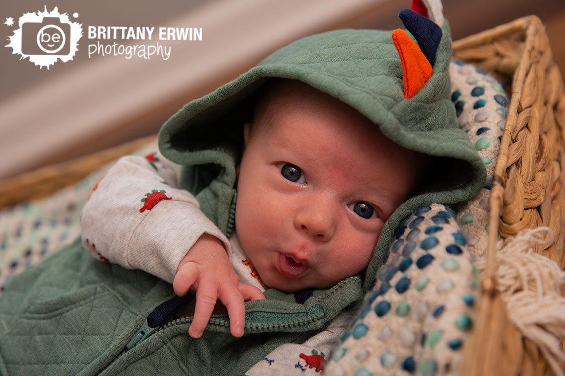 Indianapolis-lifestyle-newborn-photographer-baby-boy-in-basket-silly-face-dinosaur.jpg