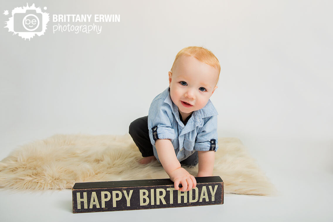 Happy-birthday-sign-boy-on-fur-rug-seamless-white-backdrop-portrait-photographer.jpg