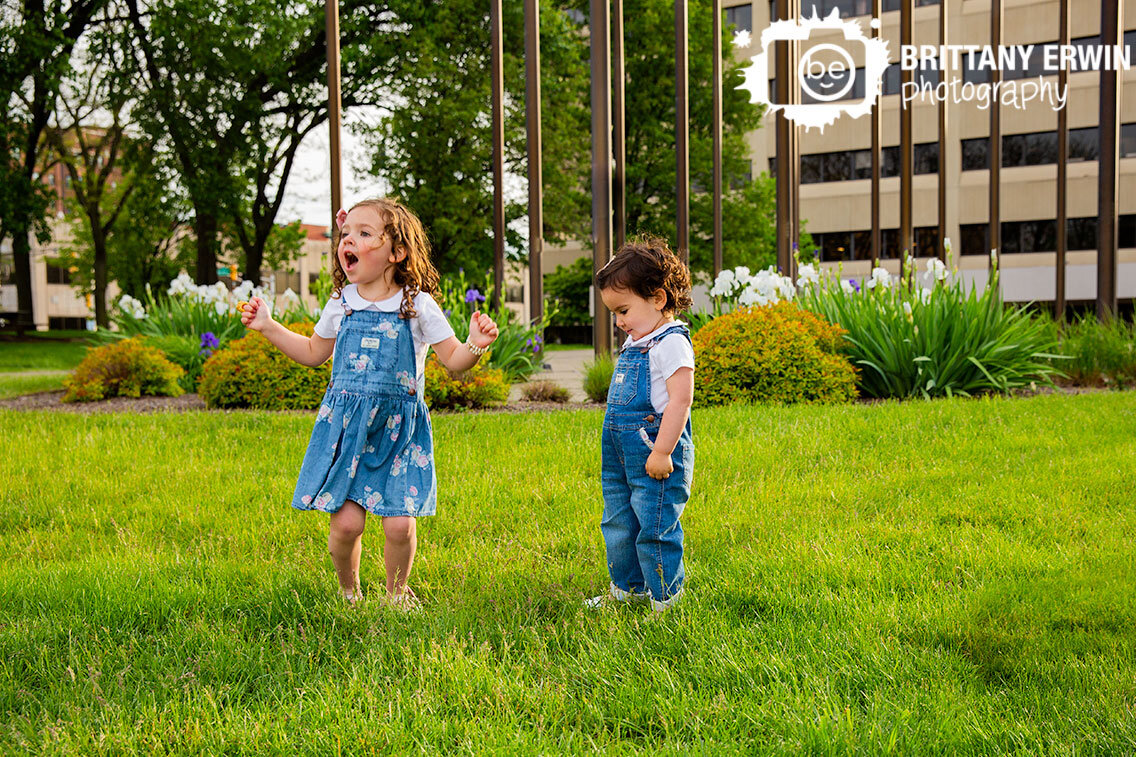 Indianapolis-downtown-siblings-portrait-photographer-girls-playing-dancing-in-grass-with-flowers.jpg