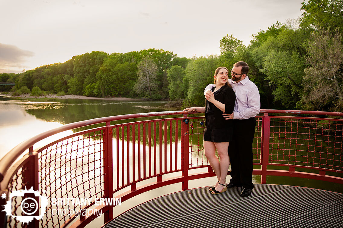 Indianapolis-monon-trail-engagement-portrait-photographer-couple-at-sunset-on-red-bridge-over-river.jpg