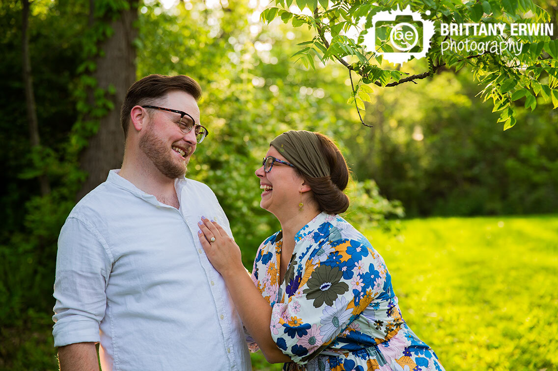 Indianapolis-engagement-portrait-photographer-couple-laughing-joking-in-field-summer-session-outside-under-trees-at-sunset.jpg