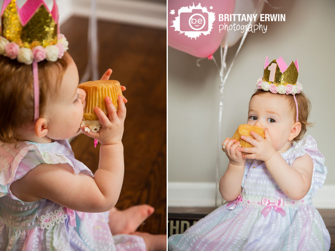 Lifestyle-first-birthday-portrait-photographer-girl-eating-cupcake-upside-down-pink-balloons-one-crown.jpg