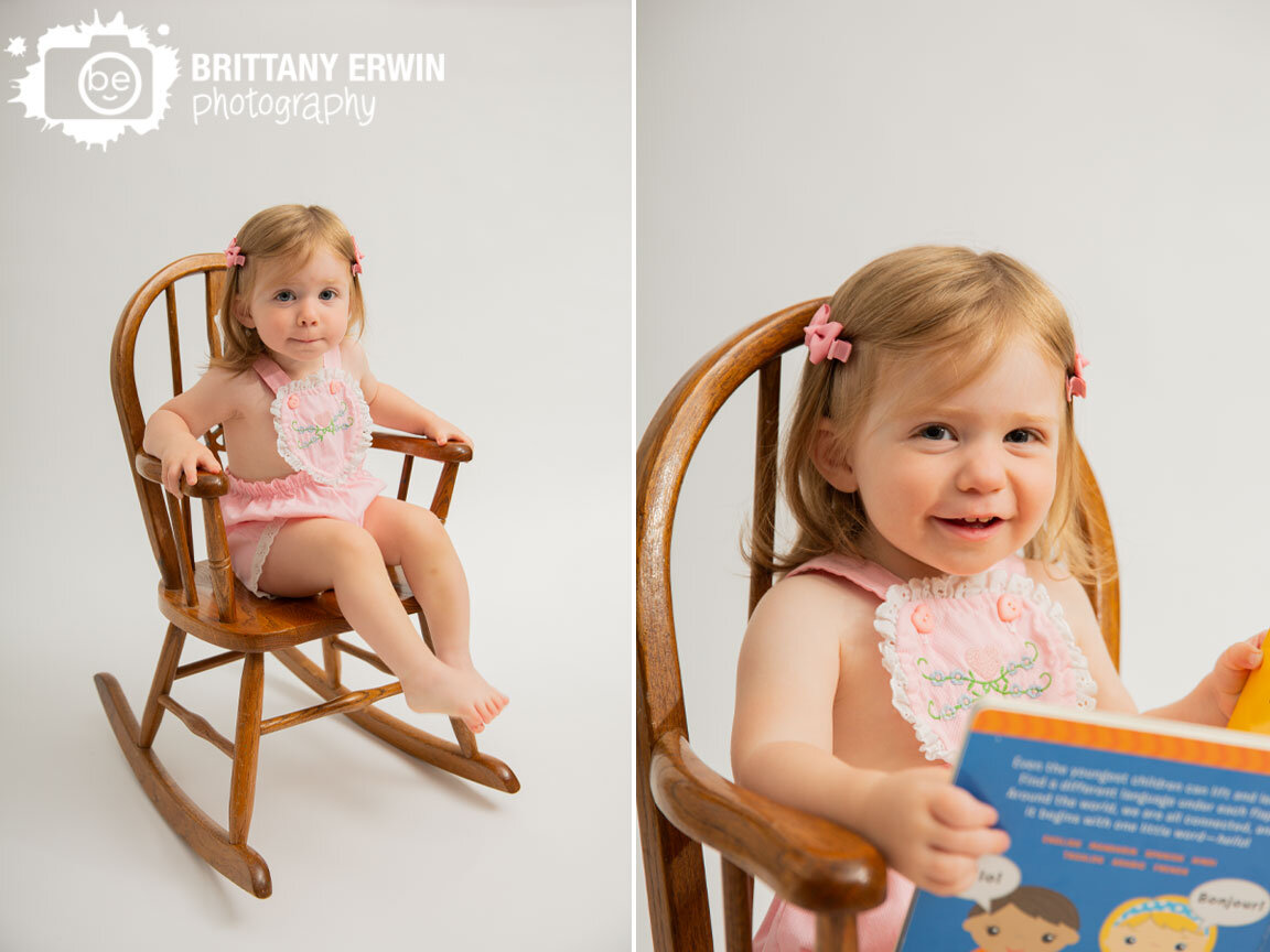 toddler-girl-in-antique-child-rocking-chair-with-classic-pink-romper-reading-book.jpg