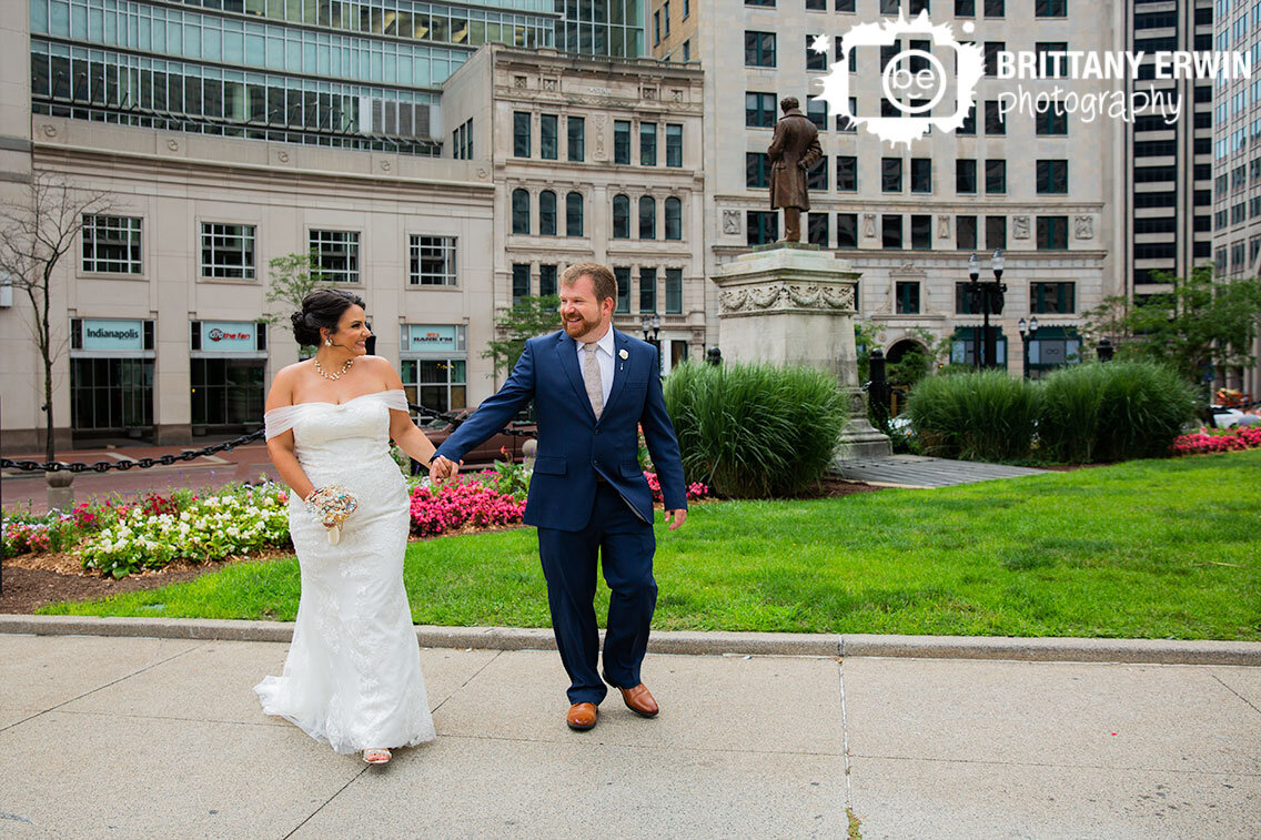 Indianapolis-wedding-photographer-couple-walking-on-monument-circle-summer-flowers.jpg