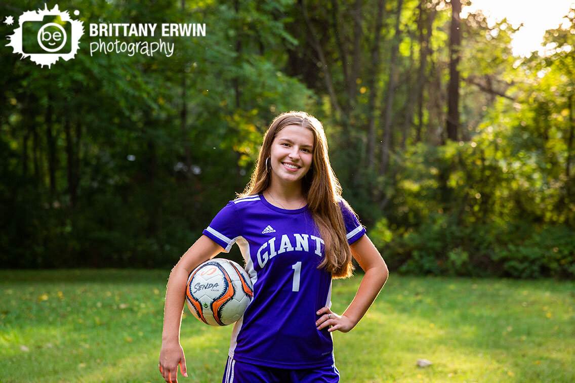 Indianapolis-high-school-senior-portrait-photographer-with-soccer-ball-under-arm-sunset-outdoor.jpg