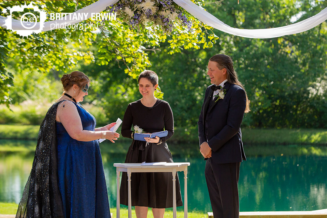 Bride-reading-vows-at-outdoor-ceremony-next-to-water.jpg