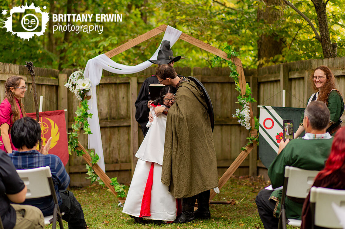 bride-and-groom-hug-after-first-kiss-at-hexagon-wooden-altar.jpg