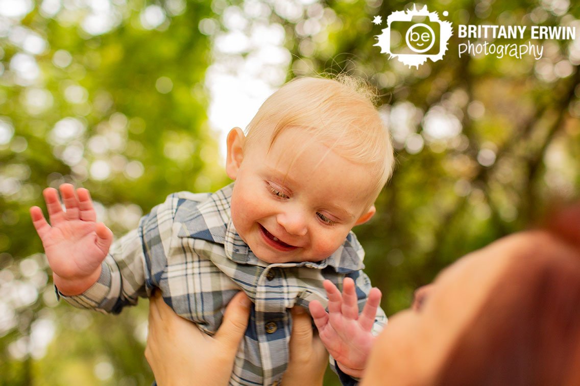 baby-boy-playing-mother-holding-up-high-outdoor-milestone-portrait-photographer.jpg
