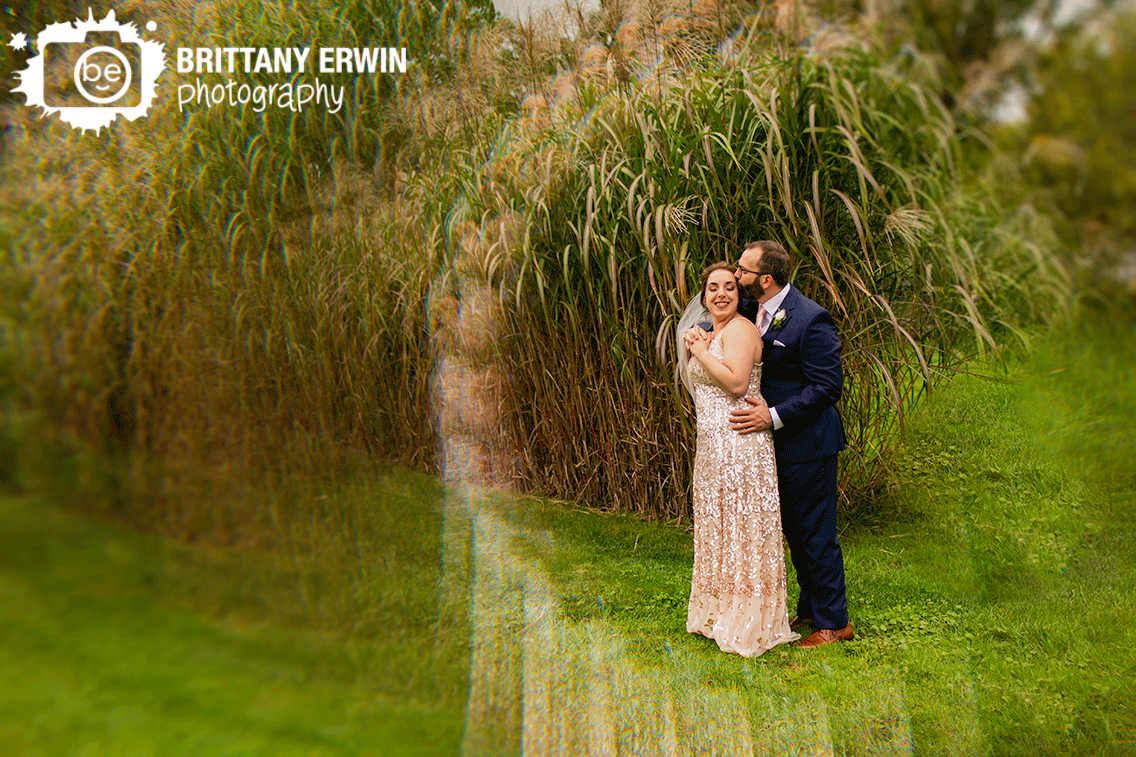Indianapolis-wedding-photographer-couple-outside-fall-with-tall-pampas-grass-cheek-kiss.gif