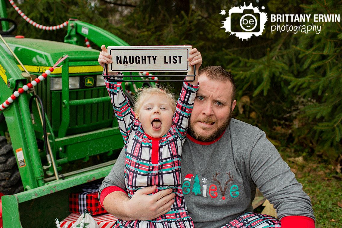 silly-christmas-portrait-naughty-list-sign-girl-with-dad.gif
