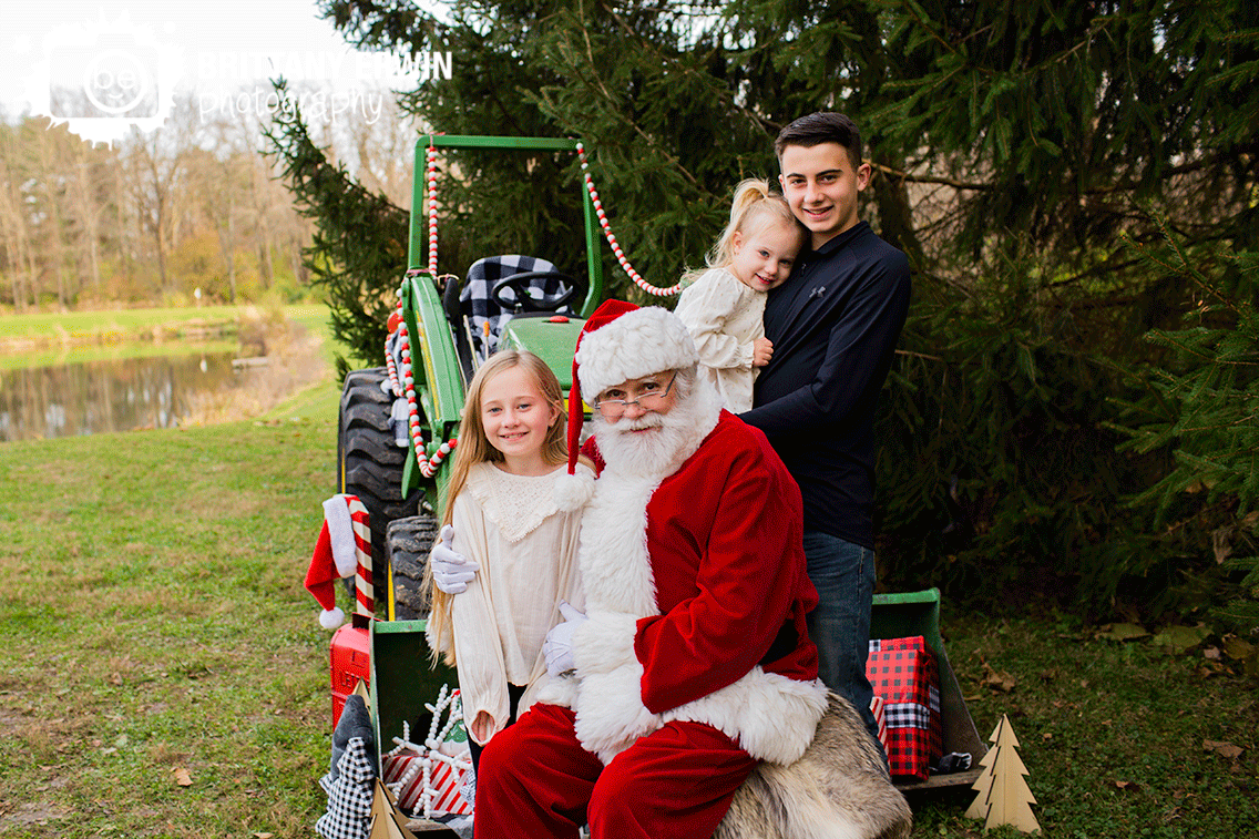 Indianapolis-portrait-photographer-siblings-with-Santa-Christmas-tractor-group.gif