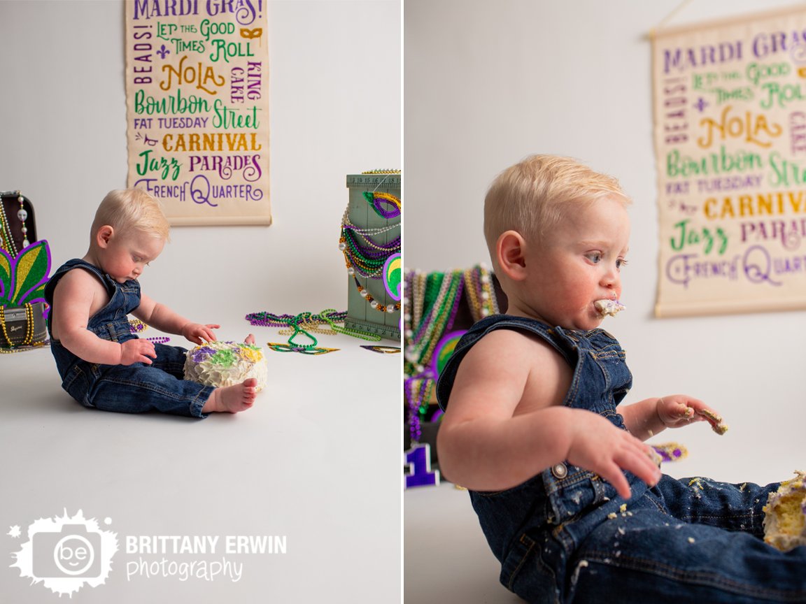 baby-boy-eating-cake-first-birthday-overalls-mardi-gras-theme.jpg