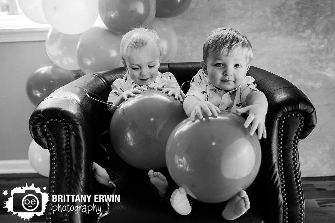 Indianapolis-portrait-photographer-twin-boys-playing-with-balloons-together-in-chair.jpg