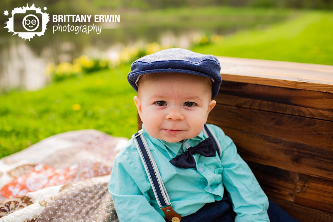 Baby-boy-milestone-portrait-outdoor-spring-bowtie-hat-and-suspenders.jpg