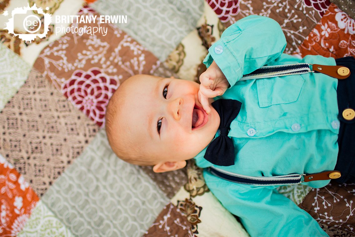 spring-baby-boy-portrait-photographer-suspenders-with-bowtie-button-down-shirt-on-quilt.jpg