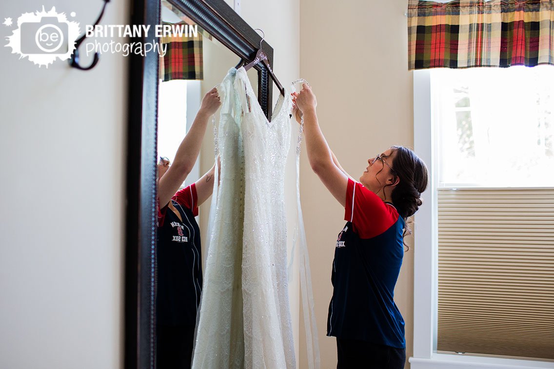 bride-adjusting-wedding-gown-on-hanger-dress-with-belt.jpg