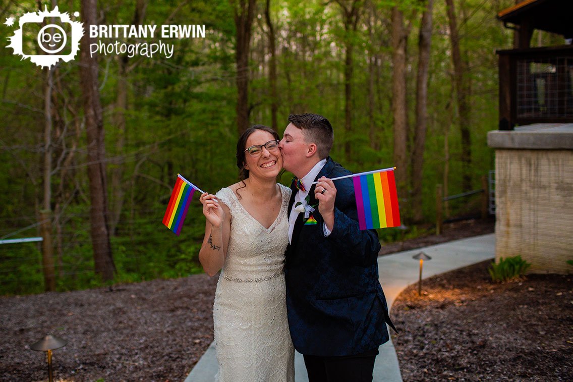 Outdoor-portrait-wedding-photographer-rainbow-pride-flags-cheek-kiss.jpg